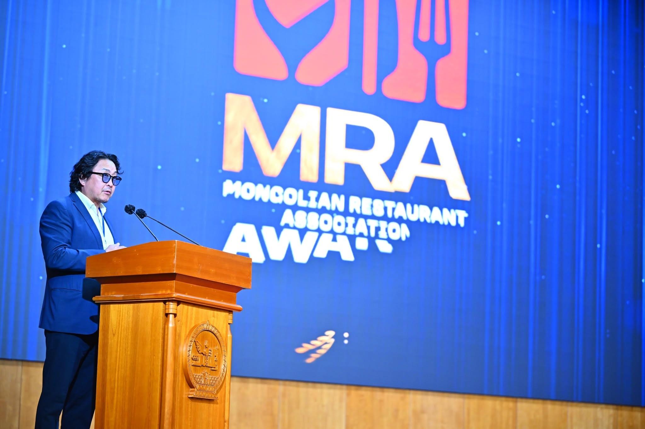MRA Awards ёслолын тайзан дээр илтгэл тавьж буй нь